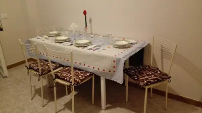 a dining room table with a white table cloth and chairs at Home Sweet Home in Rome