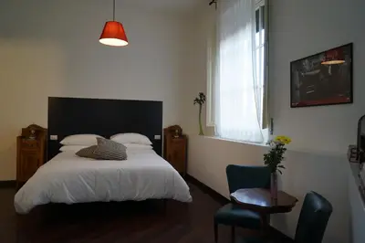 a bedroom with a bed and a chair and a window at Guest House Interno4 in Rome