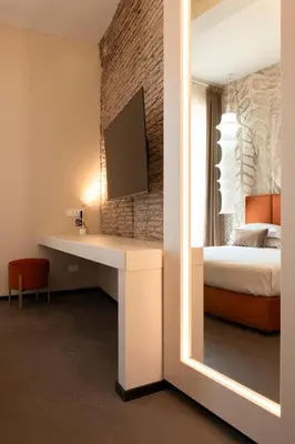 a bedroom with a desk with a bed and a mirror at Colonna Suite Del Corso in Rome