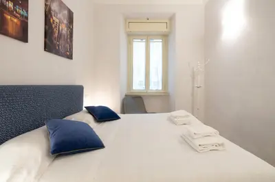 a bedroom with a large white bed with blue pillows at A 20 Gradini dai Musei Vaticani in Rome