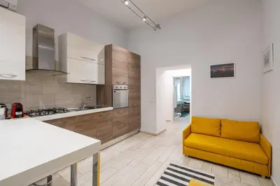 a living room with a yellow couch in a kitchen at A 20 Gradini dai Musei Vaticani in Rome