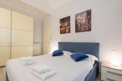 a bedroom with a white bed with blue pillows at A 20 Gradini dai Musei Vaticani in Rome