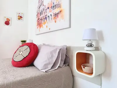 a tv sitting on top of a couch with a red pillow at Apartment Roman Haven by Interhome in Rome