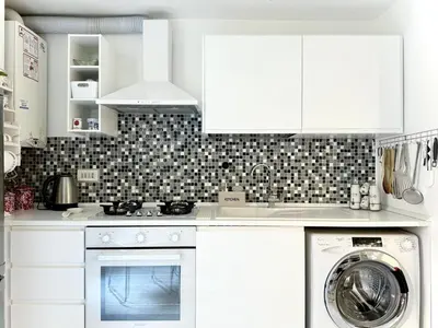 a kitchen with white cabinets and a washer and dryer at Apartment Roman Haven by Interhome in Rome