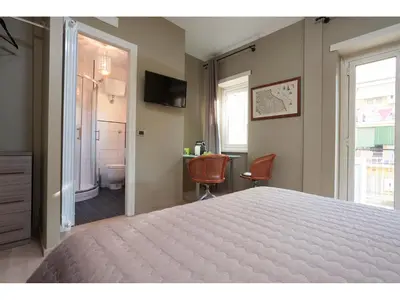 a bedroom with a large bed and a bathroom at Alex's Guest House in Rome