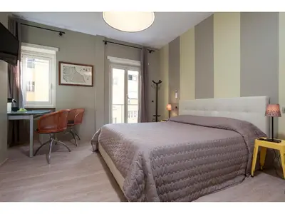 a bedroom with a bed and a desk and a chair at Alex's Guest House in Rome