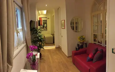 a living room with a red couch and a hallway at Margutta's Garden in Rome