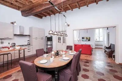 a kitchen and living room with a table and chairs at Trastevere Wonderful 3BR Apartment in Rome