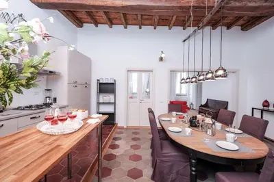 a kitchen and dining room with a large wooden table at Trastevere Wonderful 3BR Apartment in Rome