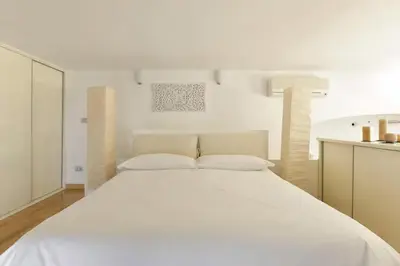 a large white bed in a white bedroom at St. Peter Loft in Rome