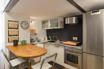 a kitchen with a wooden table and a counter top at St. Peter Loft in Rome