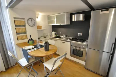 a small kitchen with a table and a refrigerator at St. Peter Loft in Rome