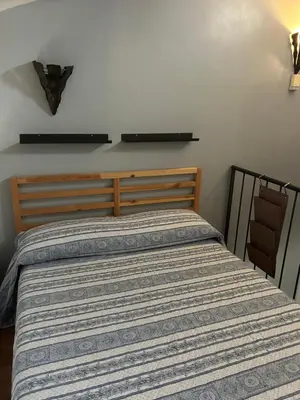 a bedroom with a bed with a striped comforter at The Queen in Rome