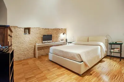 a bedroom with a white bed and a brick wall at Portico in Rome