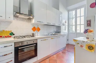 a kitchen with white cabinets and a stove top oven at Domus Eugenia in Rome