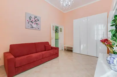 a red couch in a living room with pink walls at Domus Eugenia in Rome