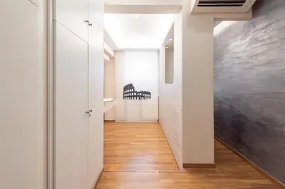 a hallway with white walls and wood floors at Top Floor Colosseo Guesthouse in Rome