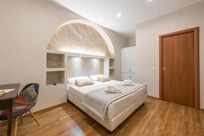 a bedroom with a large bed with an arched window at Top Floor Colosseo Guesthouse in Rome