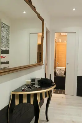 a mirror on a wall above a table in a room at Two Chic Guesthouse in Rome