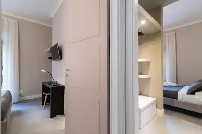 a white room with a bed and a room with a door at Ovidio Suite in Rome