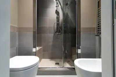 a bathroom with a shower and a toilet and a sink at Ovidio Suite in Rome