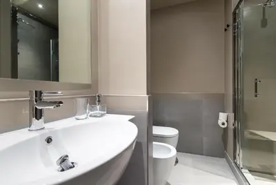 a bathroom with a sink and a toilet and a mirror at Ovidio Suite in Rome