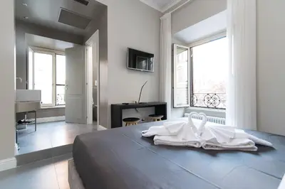 a bedroom with a large bed with a large window at Ovidio Suite in Rome