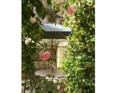a garden with roses and a spiral staircase at Viadelloca35 in Rome