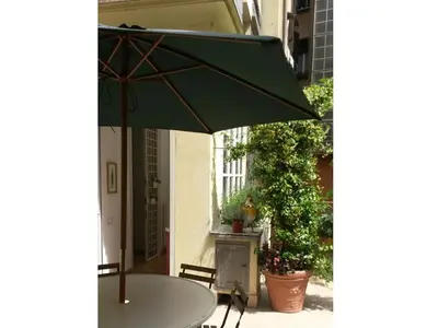a table with a green umbrella on a patio at Viadelloca35 in Rome