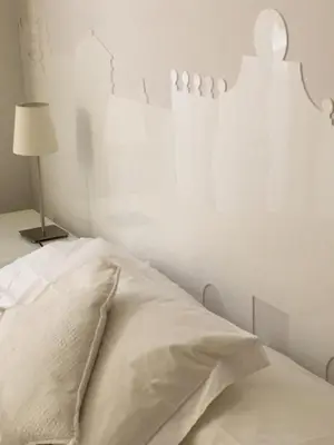 a white bedroom with a bed and a lamp at Viadelloca35 in Rome
