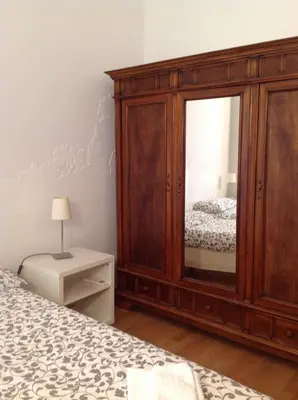 a bedroom with a wooden cabinet with a mirror at Viadelloca35 in Rome