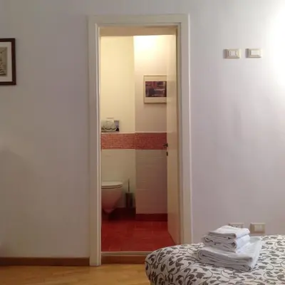 a bathroom with a toilet and a bed in a room at Viadelloca35 in Rome