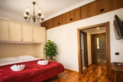 a bed with two white pillows on a red blanket at EXCELLENT Palace in Rome