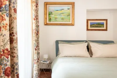 a bedroom with a bed with two pictures on the wall at Annemary Maison in Rome