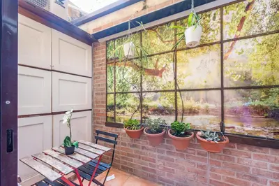 a patio with a table and potted plants on a wall at BHM Urban House Pigneto in Rome