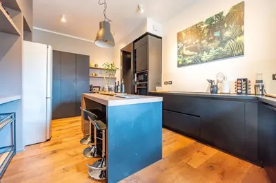 a kitchen with black cabinets and a blue island at Residenza Pasolini in Rome
