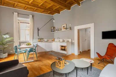 a living room with a couch and tables and a fireplace at Campo de Fiori Bright Loft in Rome