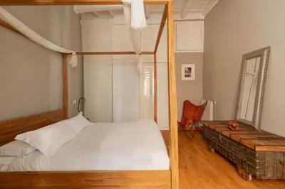a bedroom with a four poster bed and a chair at Campo de Fiori Bright Loft in Rome