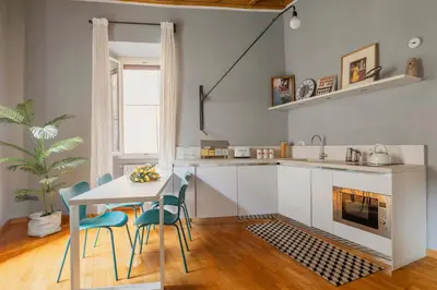 a kitchen with a table and chairs and a fireplace at Campo de Fiori Bright Loft in Rome