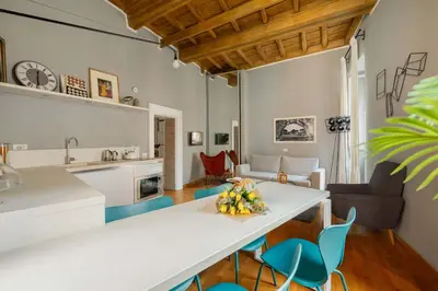 a kitchen and living room with a table and chairs at Campo de Fiori Bright Loft in Rome