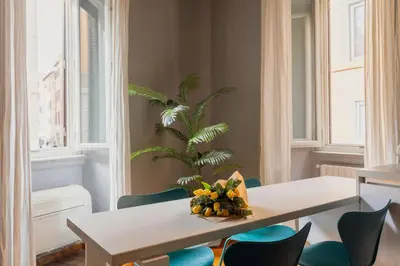 a dining room with a table and chairs and a palm tree at Campo de Fiori Bright Loft in Rome