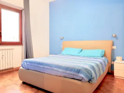 a bedroom with a bed with blue walls and a window at Vatican Area Flat in Rome