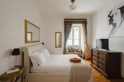 a bedroom with a bed with a television and a dresser at B&B Ibiscus in Rome