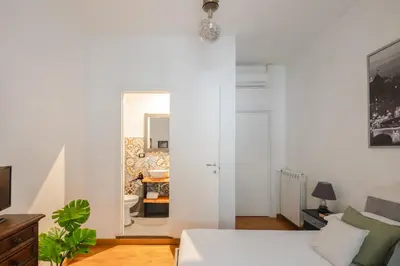 a white room with a bed and a living room at B&B Ibiscus in Rome