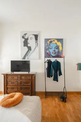a bedroom with a bed and a dresser and paintings at B&B Ibiscus in Rome