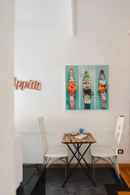 a table and chairs in a room with two paintings on the wall at B&B Ibiscus in Rome