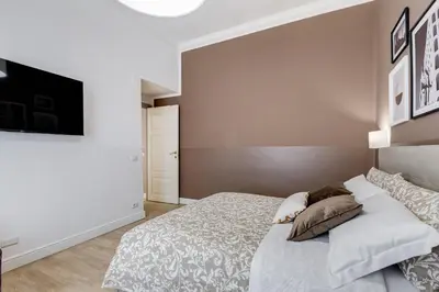 a bedroom with a bed and a tv on a wall at BDC - The Choice, your 2-Bdr apt in Vatican district in Rome