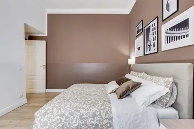 a bedroom with a white bed and a wall with pictures at BDC - The Choice, your 2-Bdr apt in Vatican district in Rome