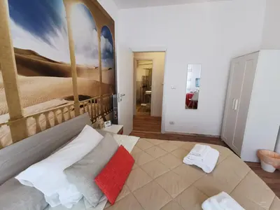 a bedroom with a bed with a painting on the wall at La Finestra Sul Mondo B&B in Rome