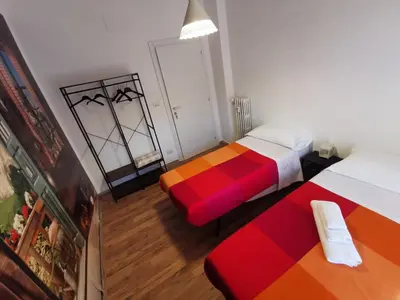 a small room with two beds and a mirror at La Finestra Sul Mondo B&B in Rome